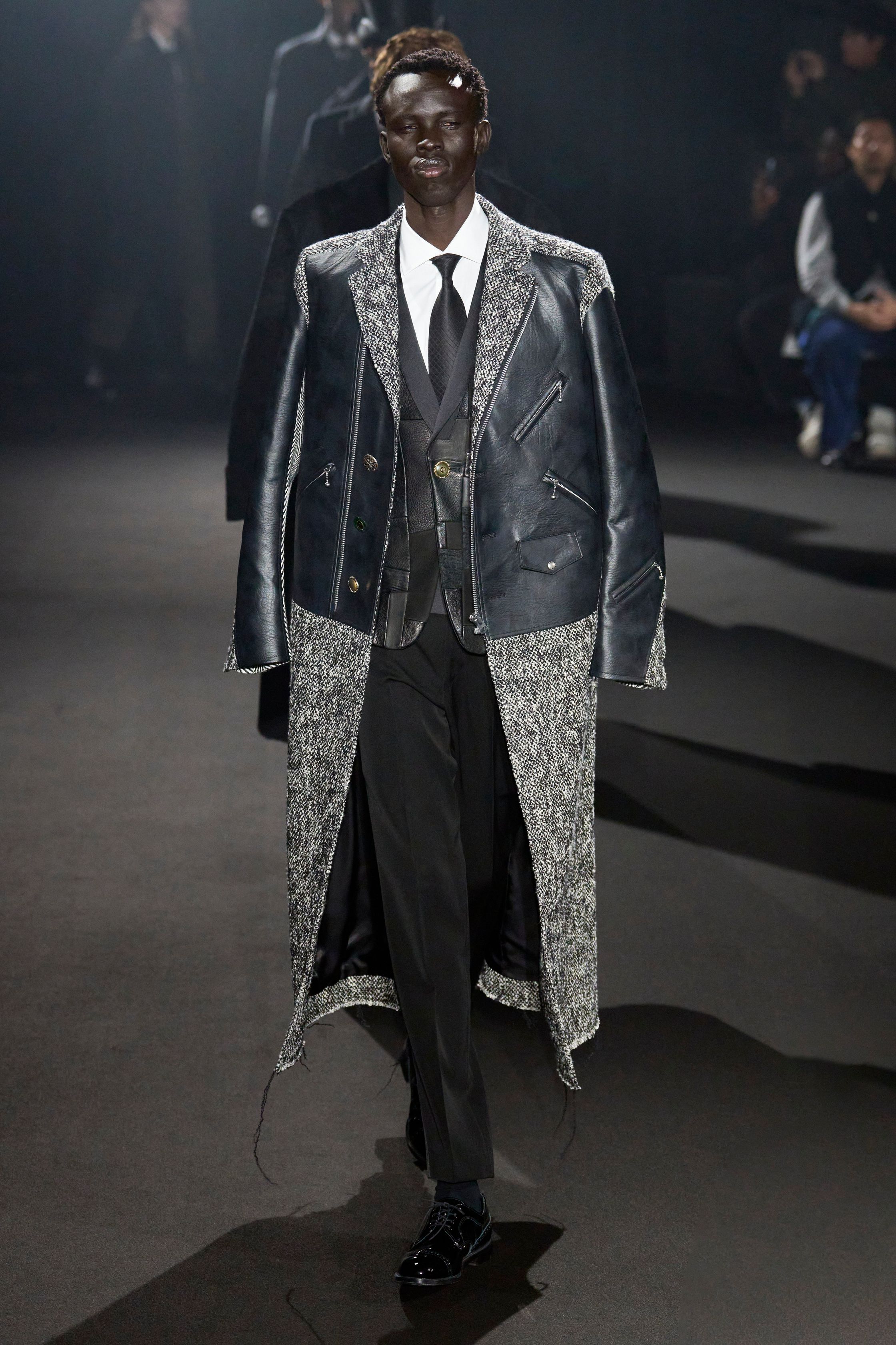 Junya Watanabe 本季以高级拼接与结构实验重塑经典男装：西装、皮革、格纹与工装被解构再组合，形成极具张力的层次秩序。熟悉的正装符号被“错误使用”，制造出不稳定却高度精密的视觉冲突，延续品牌对“功能、秩序与混乱”的长期探索-顽石频道趋势研究